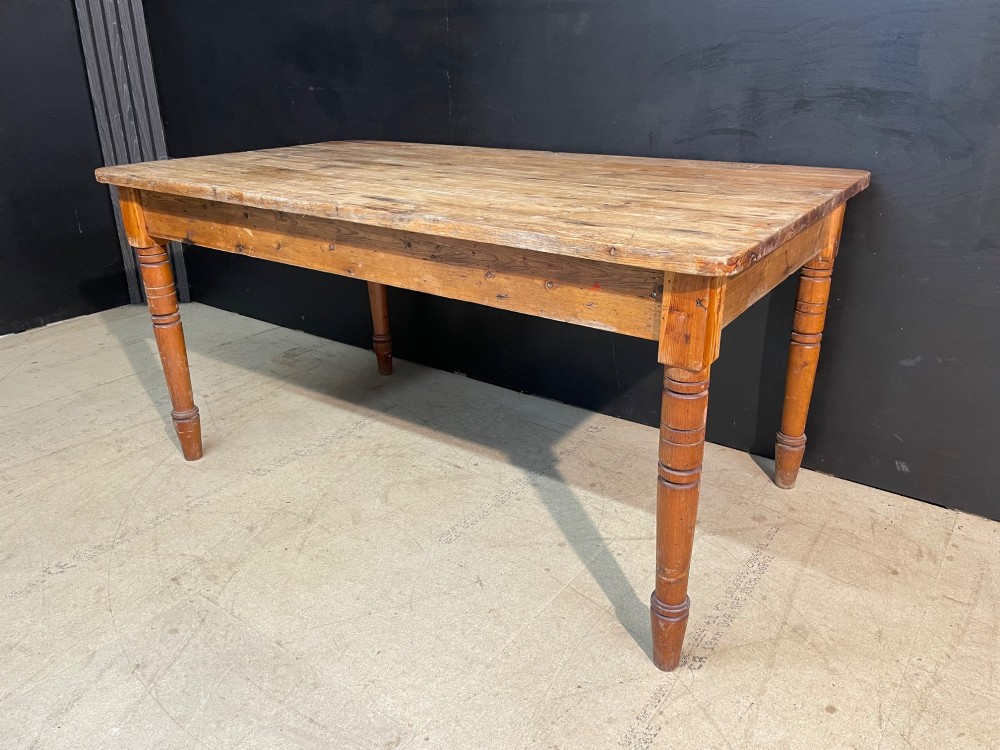 A rectangular pine farmhouse dining table with turned wooden legs and a planked top. View IV