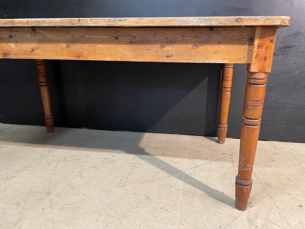 A rectangular pine farmhouse dining table with turned wooden legs and a planked top. View VI