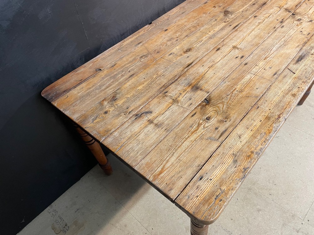 A rectangular pine farmhouse dining table with turned wooden legs and a planked top. View VIII