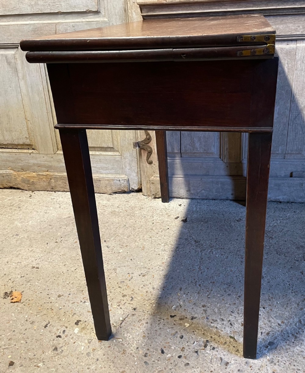 A Georgian oak fold-over tea table featuring a single central frieze drawer with a brass drop handle and straight tapered legs. View VII