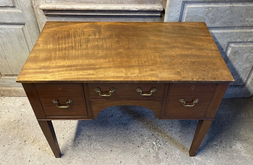A 19th-century mahogany lowboy with three drawers, brass swan-neck handles, an arched lower apron, and square tapered legs. View II