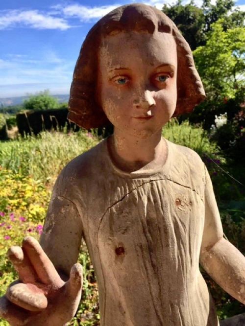 fig 3. A carved wooden polychrome figure depicting the young Christ standing on a stepped base, holding an orb in one hand and raising the other in blessing.