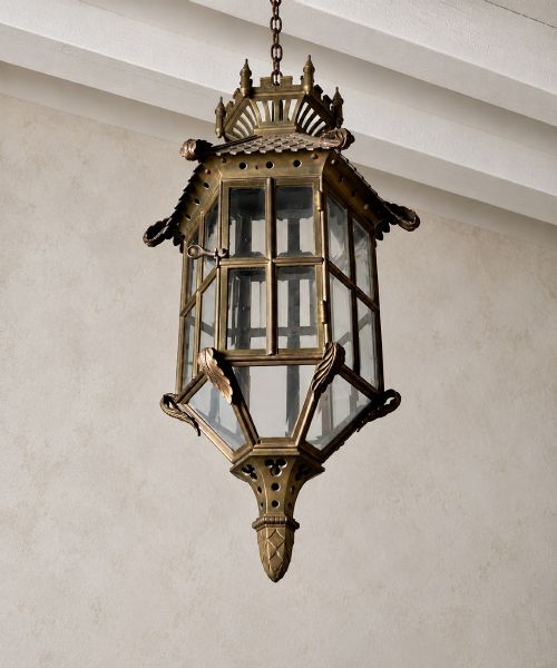 fig 2. A large Continental Gothic Revival bronze hanging lantern featuring a castellated crown roof with turrets, scale detailing, and glass panels.