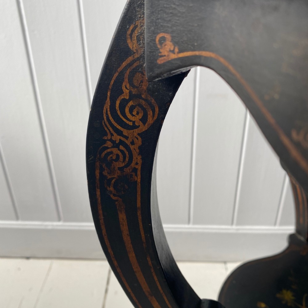 A Victorian ebonised black wooden sewing table featuring hand-painted floral designs, a painted landscape scene on the lid, cabriole legs, and a lower undertier. View II
