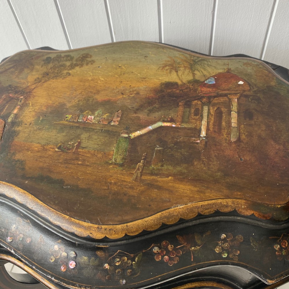 A Victorian ebonised black wooden sewing table featuring hand-painted floral designs, a painted landscape scene on the lid, cabriole legs, and a lower undertier. View V