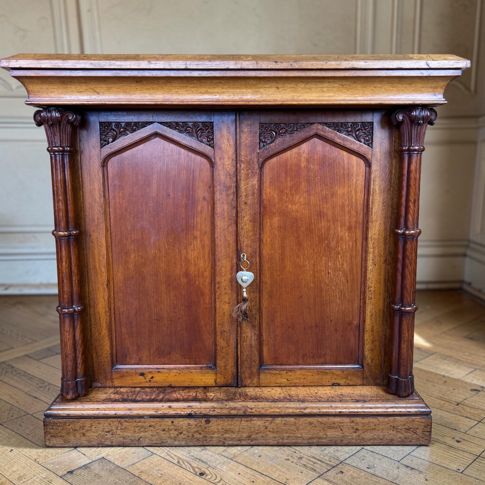 A William IV Gothic Revival oak side cabinet featuring twin pointed-arch panelled doors flanked by turned columns. View II