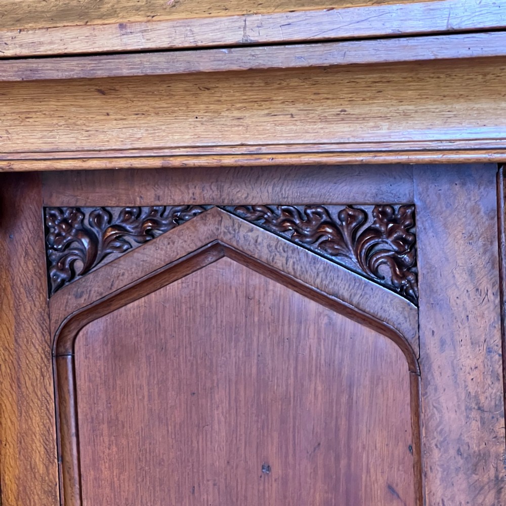 A William IV Gothic Revival oak side cabinet featuring twin pointed-arch panelled doors flanked by turned columns. View VI