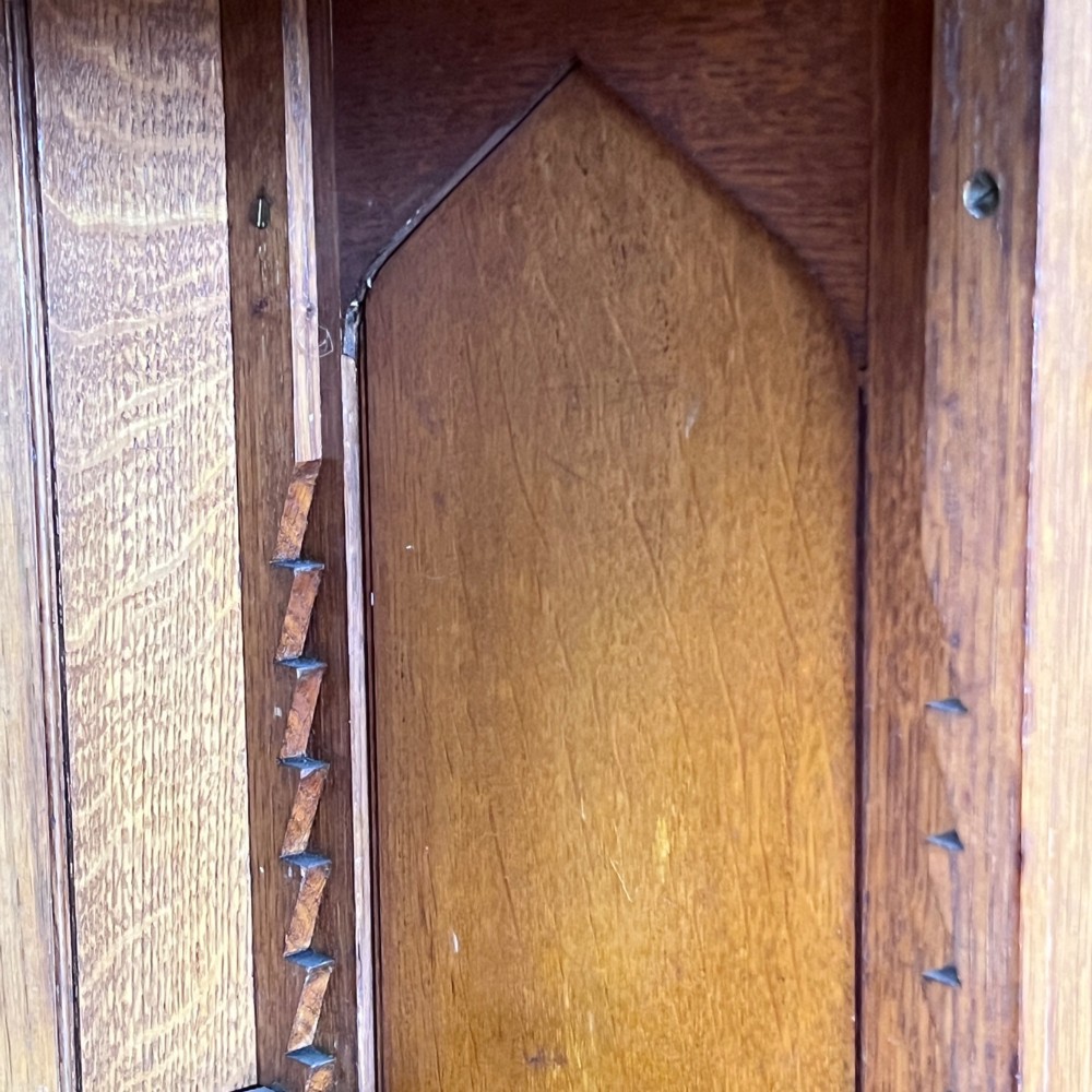 A William IV Gothic Revival oak side cabinet featuring twin pointed-arch panelled doors flanked by turned columns. View VII