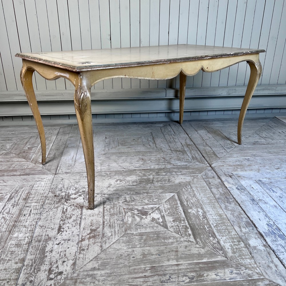 A rectangular French Louis XV Revival dining table featuring a cream painted finish, gold leaf accents, curved cabriole legs, and a scalloped apron. View IV