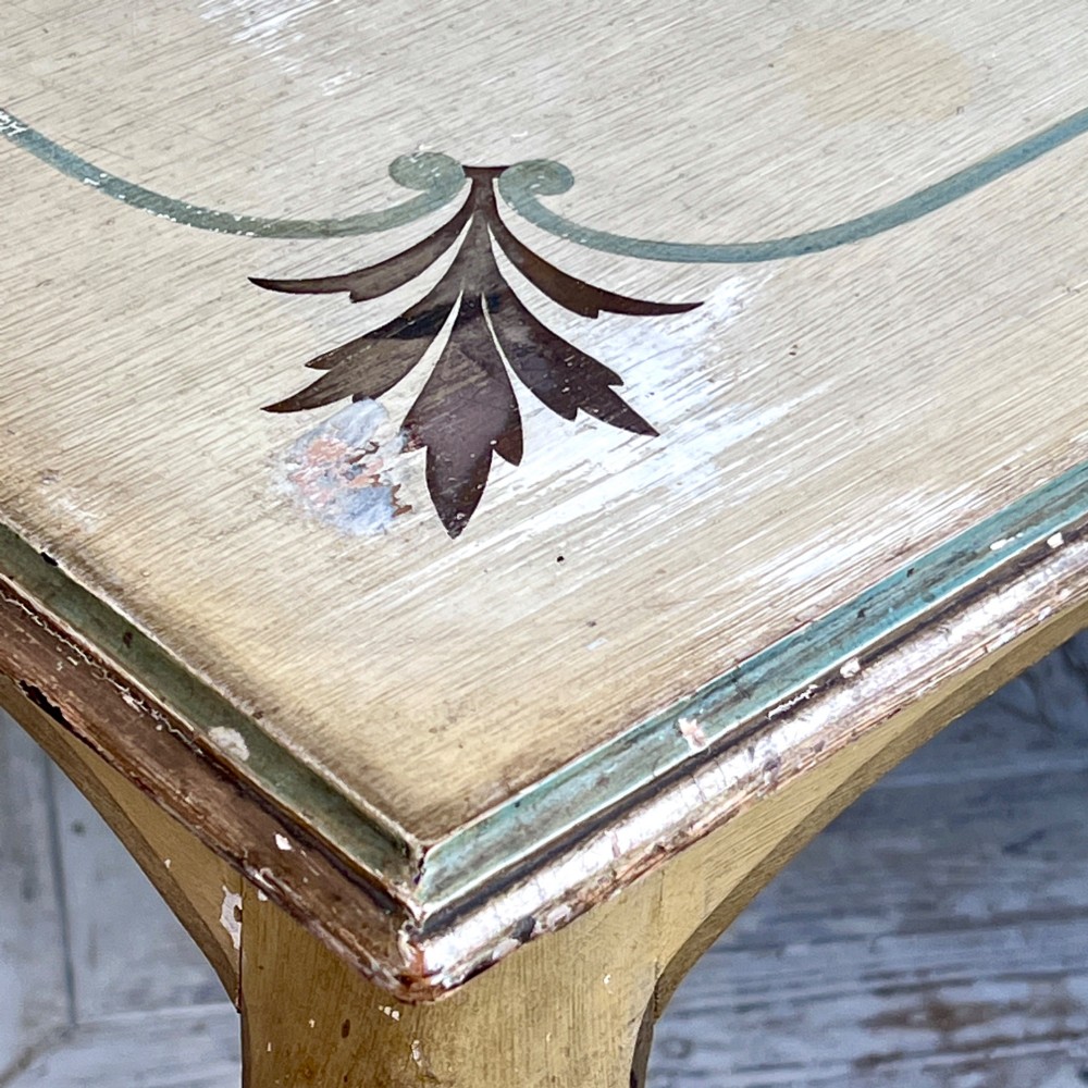 A rectangular French Louis XV Revival dining table featuring a cream painted finish, gold leaf accents, curved cabriole legs, and a scalloped apron. View VII
