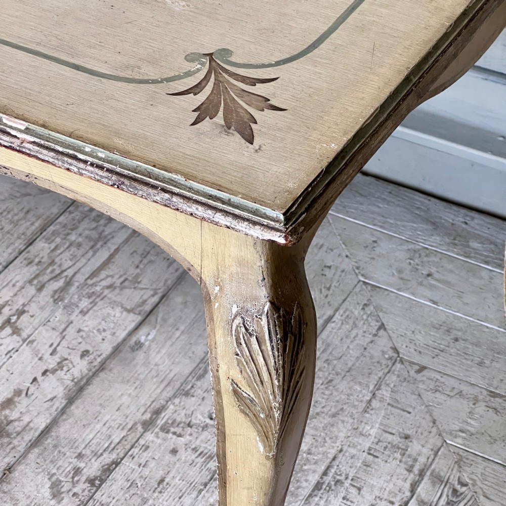 A rectangular French Louis XV Revival dining table featuring a cream painted finish, gold leaf accents, curved cabriole legs, and a scalloped apron. View XI