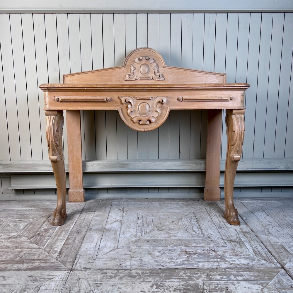 A Victorian carved pine console table featuring front cabriole legs, a central relief cartouche, and a shaped gallery backrest. View III