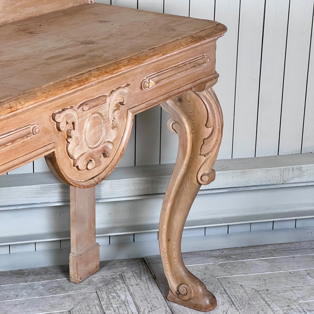 A Victorian carved pine console table featuring front cabriole legs, a central relief cartouche, and a shaped gallery backrest. View V