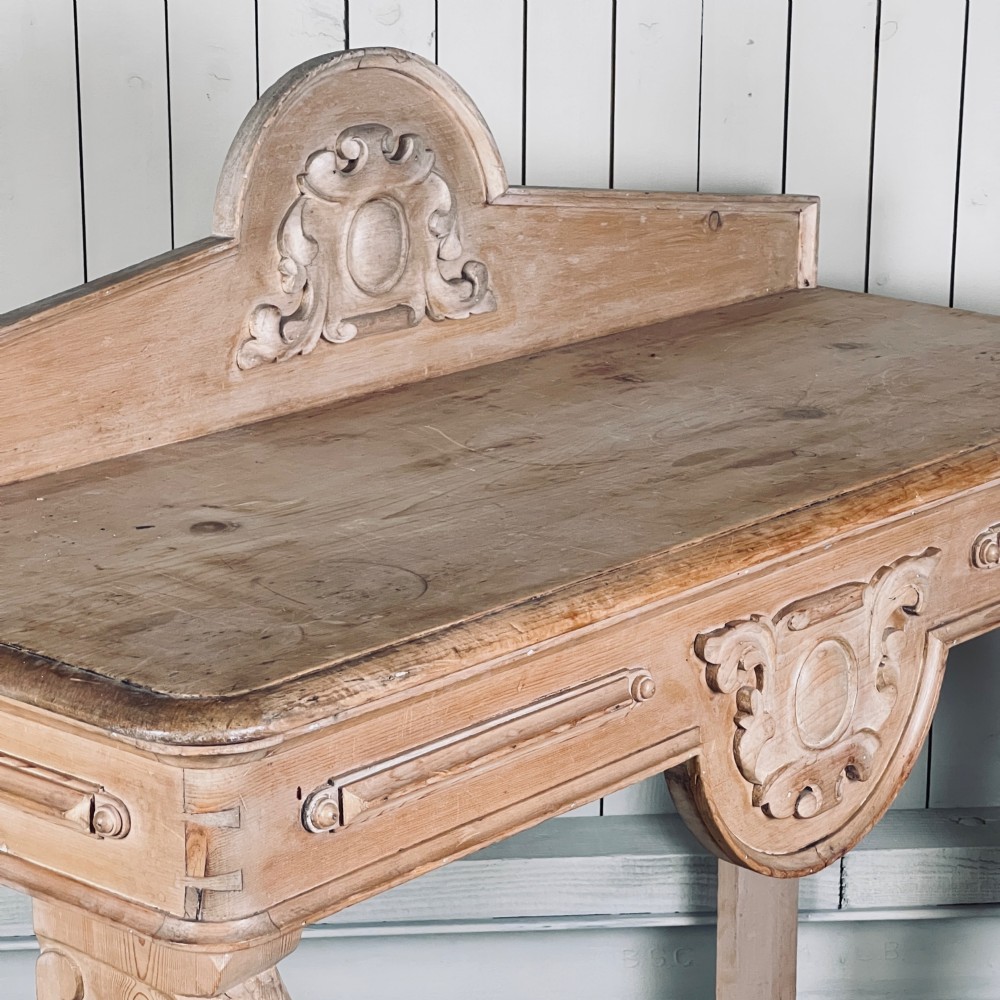 A Victorian carved pine console table featuring front cabriole legs, a central relief cartouche, and a shaped gallery backrest. View VI