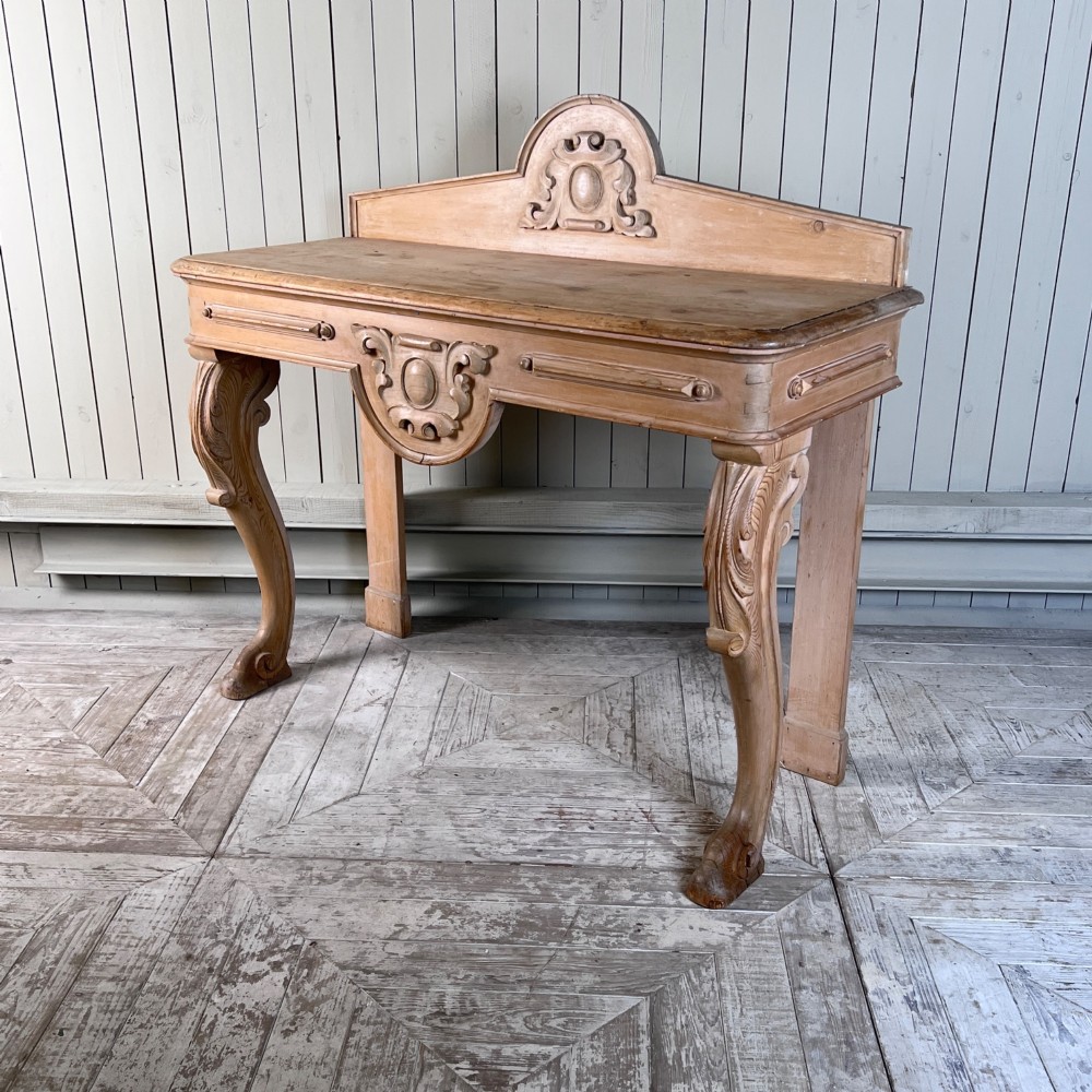 A Victorian carved pine console table featuring front cabriole legs, a central relief cartouche, and a shaped gallery backrest. View IX
