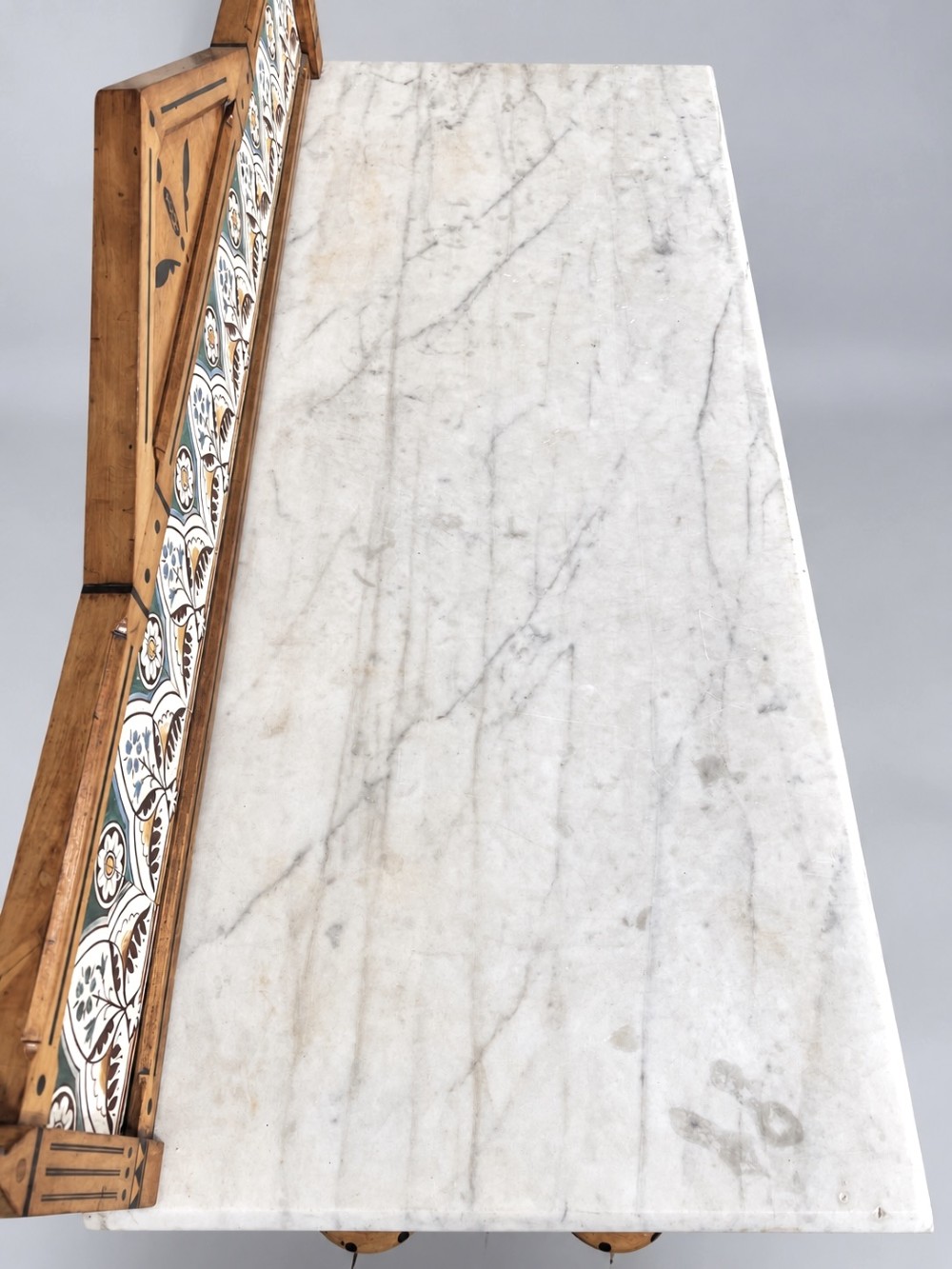 A Victorian Reformed Gothic washstand featuring a white marble top, turned legs, a tiled splashback, and geometric dark wood inlays. View X