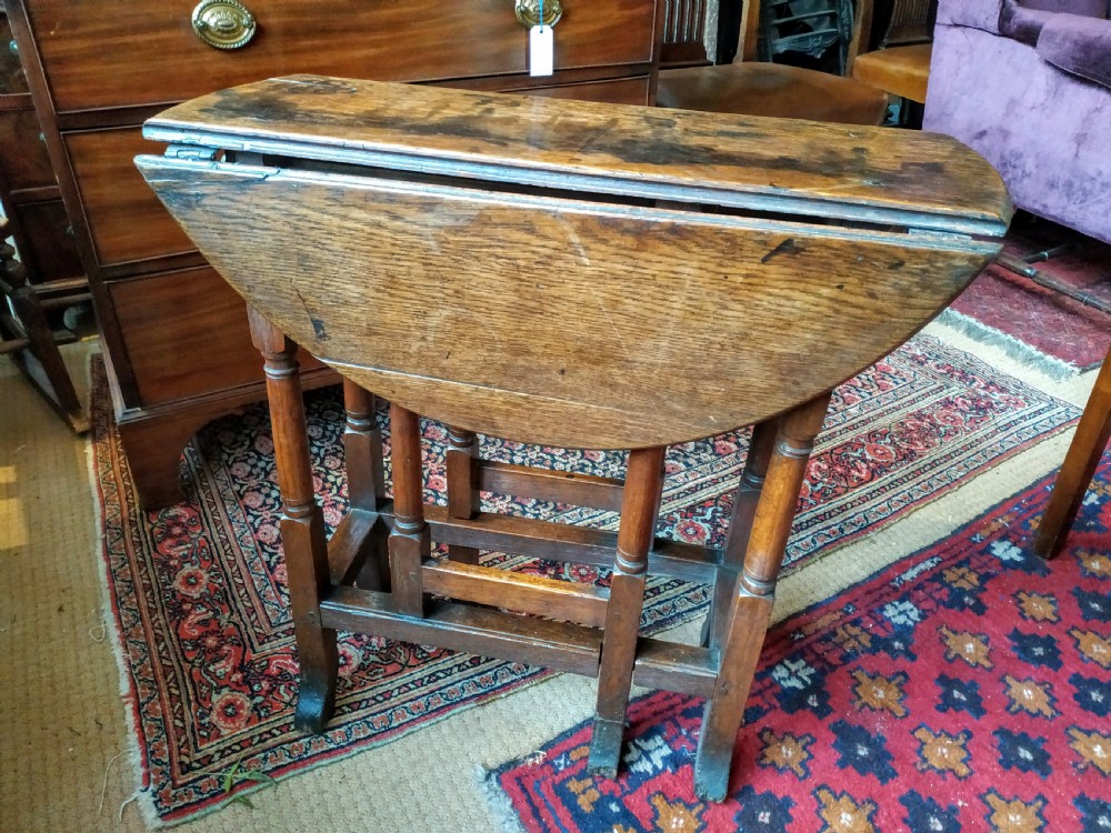A 19th-century round oak gateleg occasional table featuring a drop-leaf top, turned legs, and a lower stretcher frame. View II