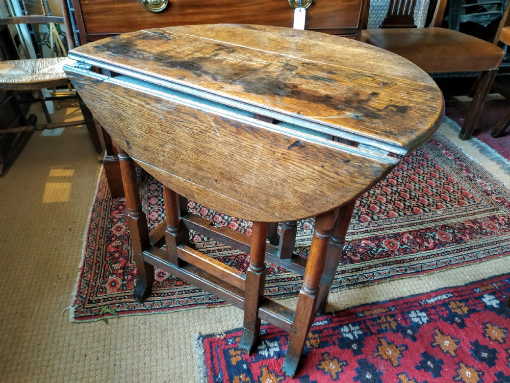 A 19th-century round oak gateleg occasional table featuring a drop-leaf top, turned legs, and a lower stretcher frame. View III