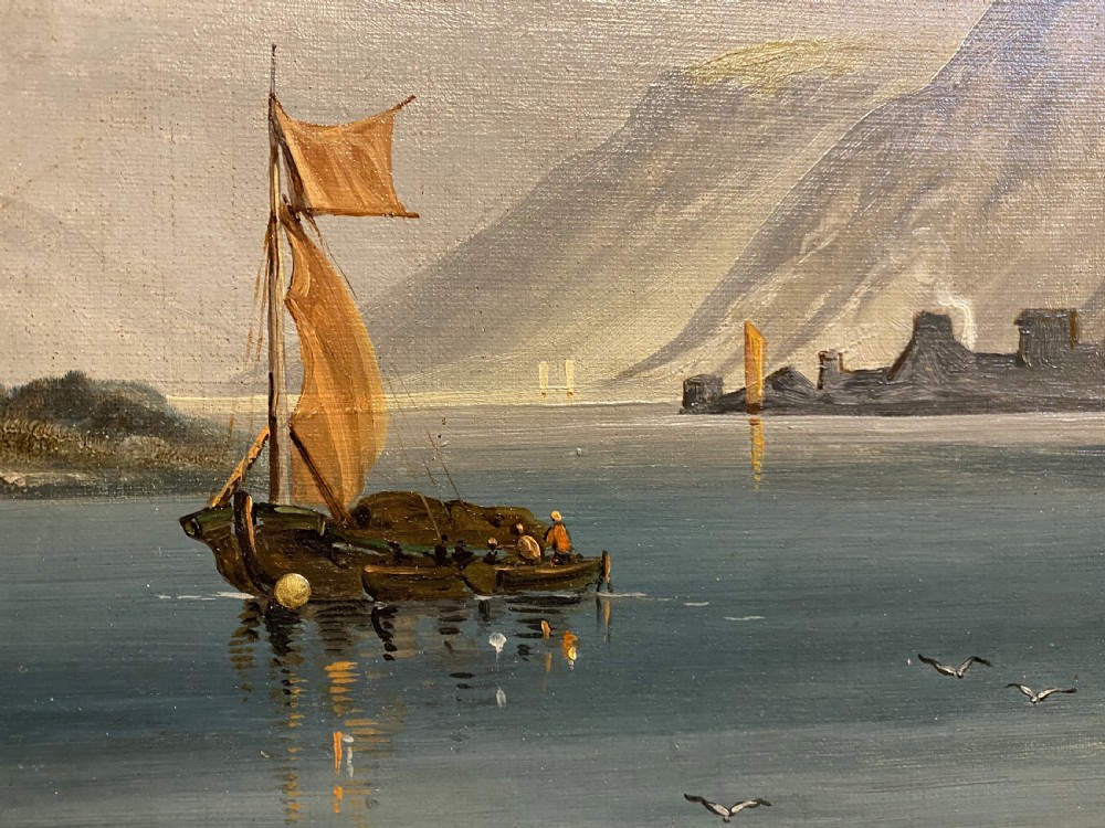 An antique oil painting depicting a river scene with a sailboat, distant castle on a hill, and mountains, housed in an ornate giltwood frame. View IV