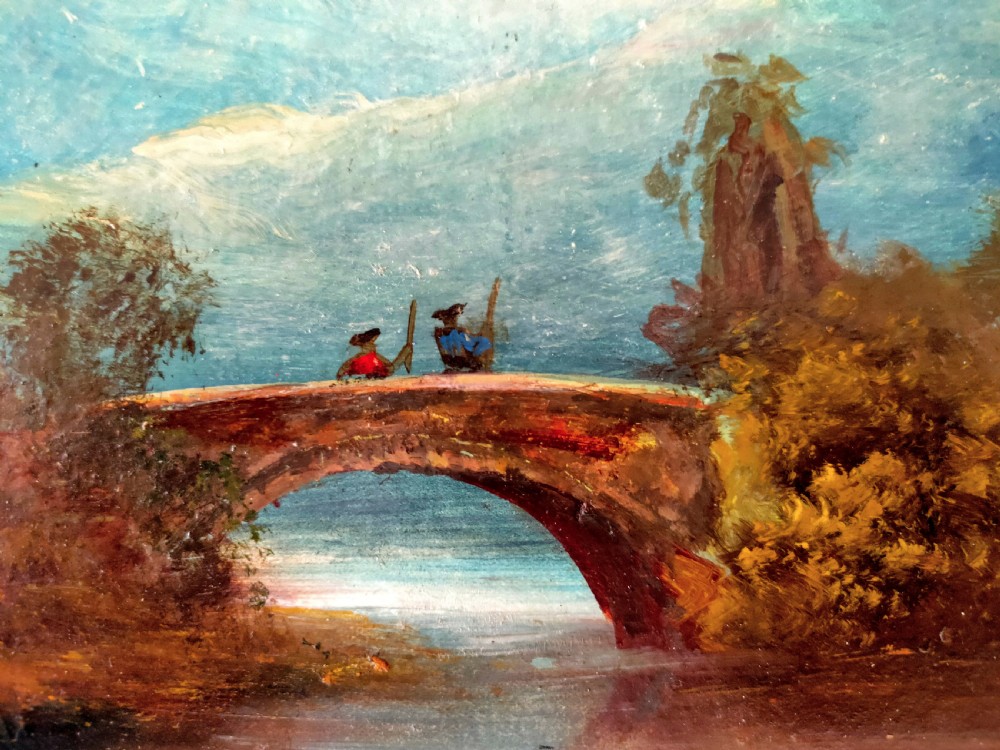 An antique landscape oil painting portraying two figures standing on a stone arch bridge over a river with blue mountains in the background, set inside an ornate gold frame. View II