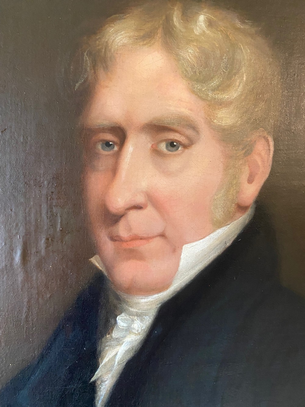 A 19th-century oil painting depicting a fair-haired gentleman in a dark frock coat and white cravat, set within an ornate gilded frame. View II