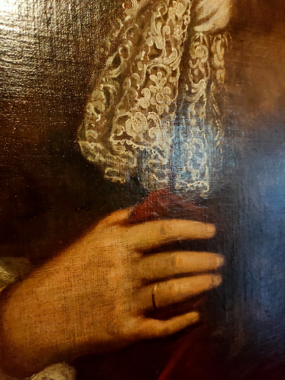 A seventeenth-century oval oil painting on canvas depicting a gentleman with a long wig, lace cravat, and crimson cloak, set within a carved wood frame. View IV