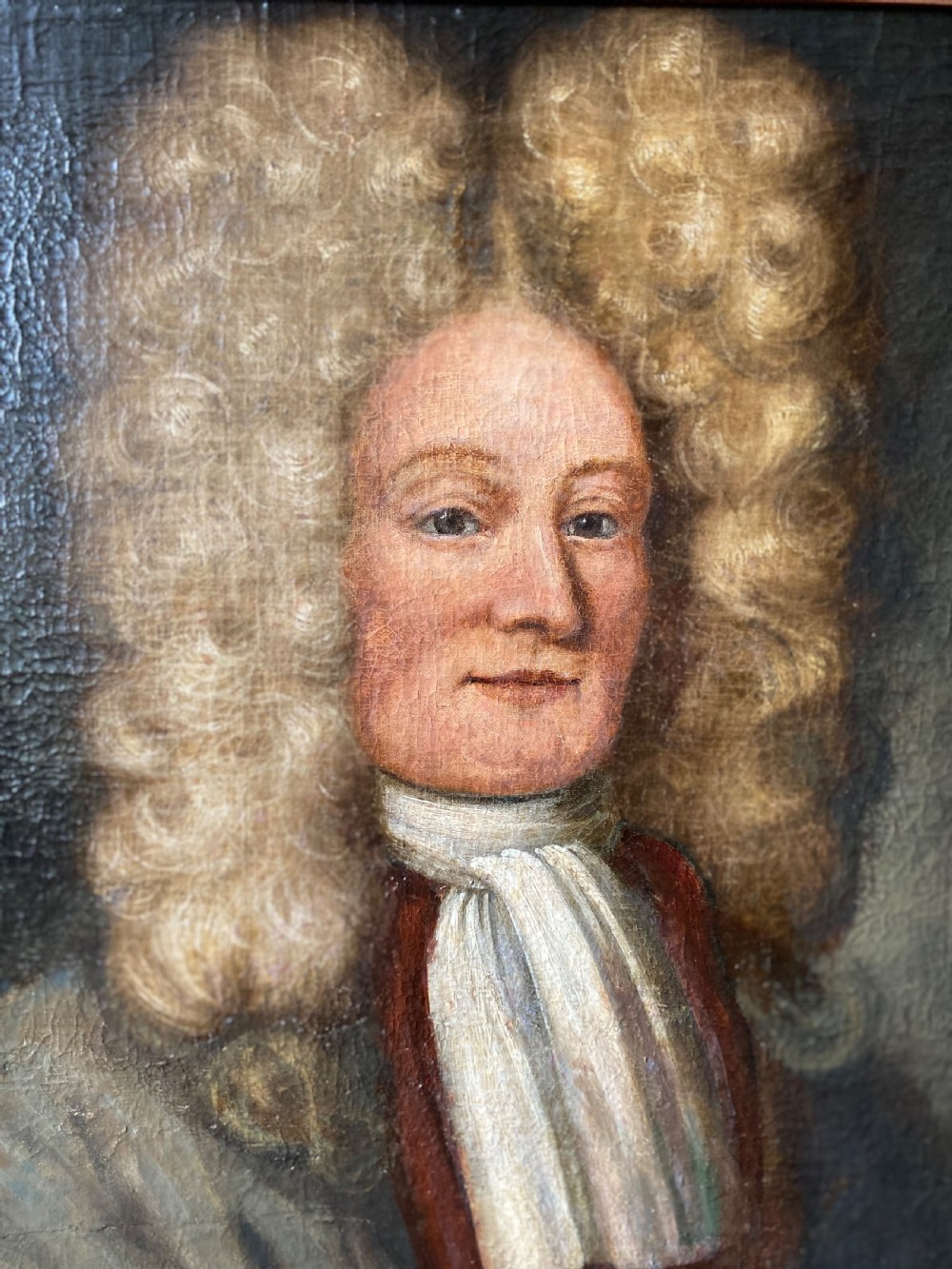 An 18th-century oil painting depicting a gentleman wearing a powdered wig and white cravat, framed within a wide oak wood border. View IV