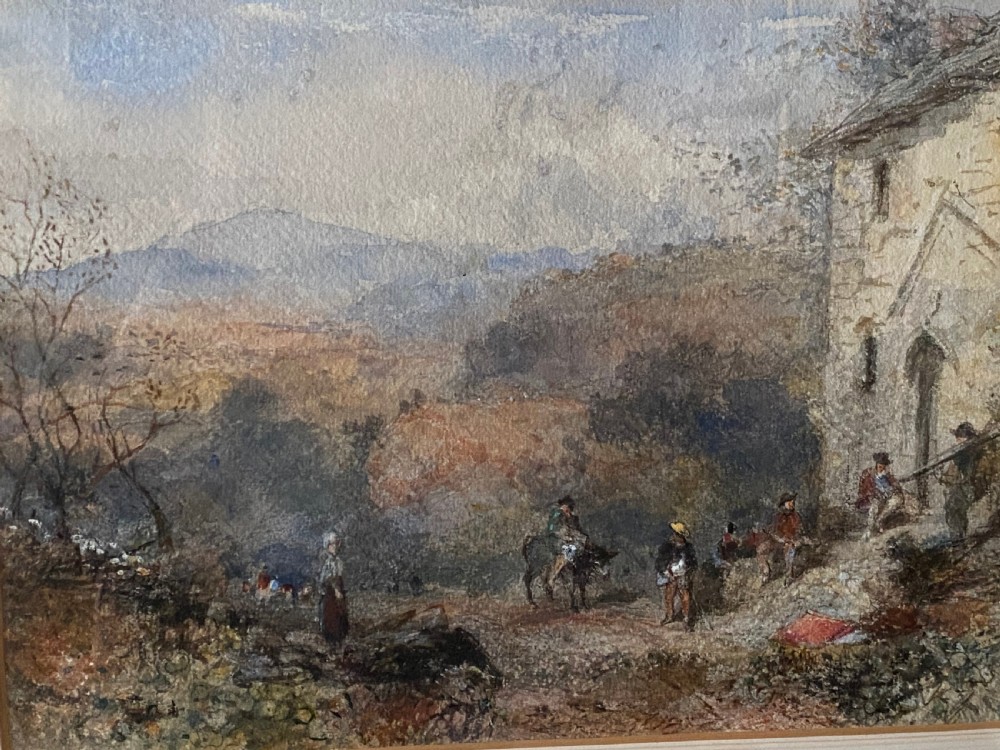 An early 20th-century watercolour painting depicting figures near a rustic stone building in a hilly landscape, presented in a gilded frame. View VI
