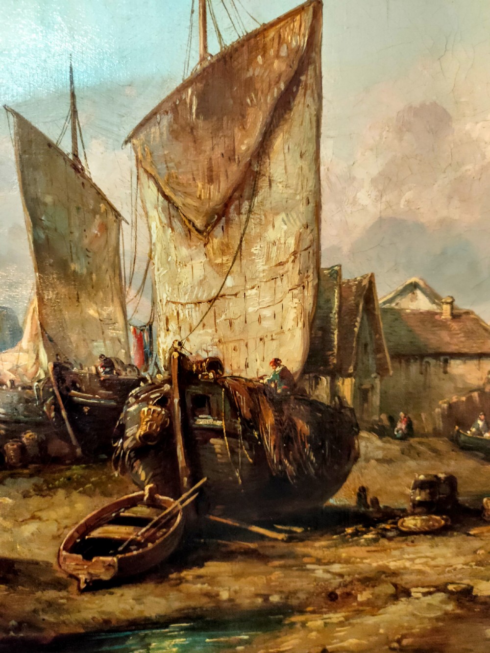 A 19th-century oil painting depicting fishermen and sailing vessels in a coastal harbour, housed in an ornate gilt swept frame. View IV