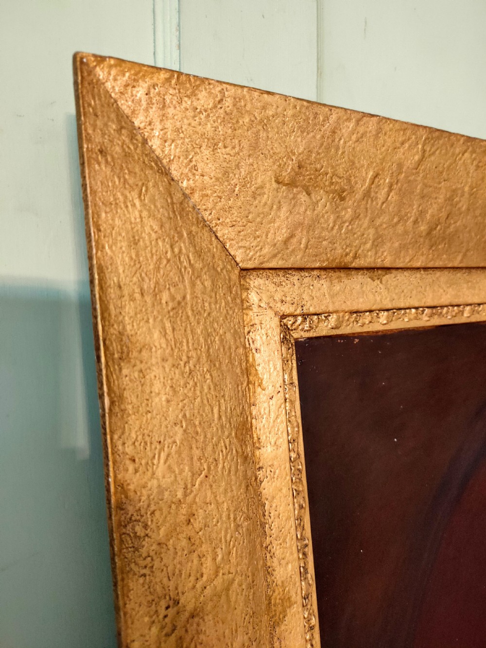 An antique oil painting depicting an elder woman in a lace stole set against a dark background within a wide gilt frame. View IV