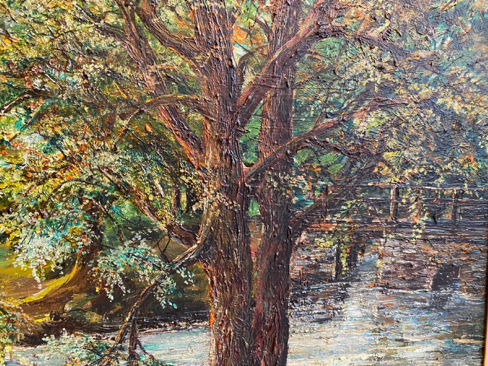 A framed oil painting featuring a heavily textured woodland riverbank scene with large trees leaning over a body of water in a dark wooden frame. View VI