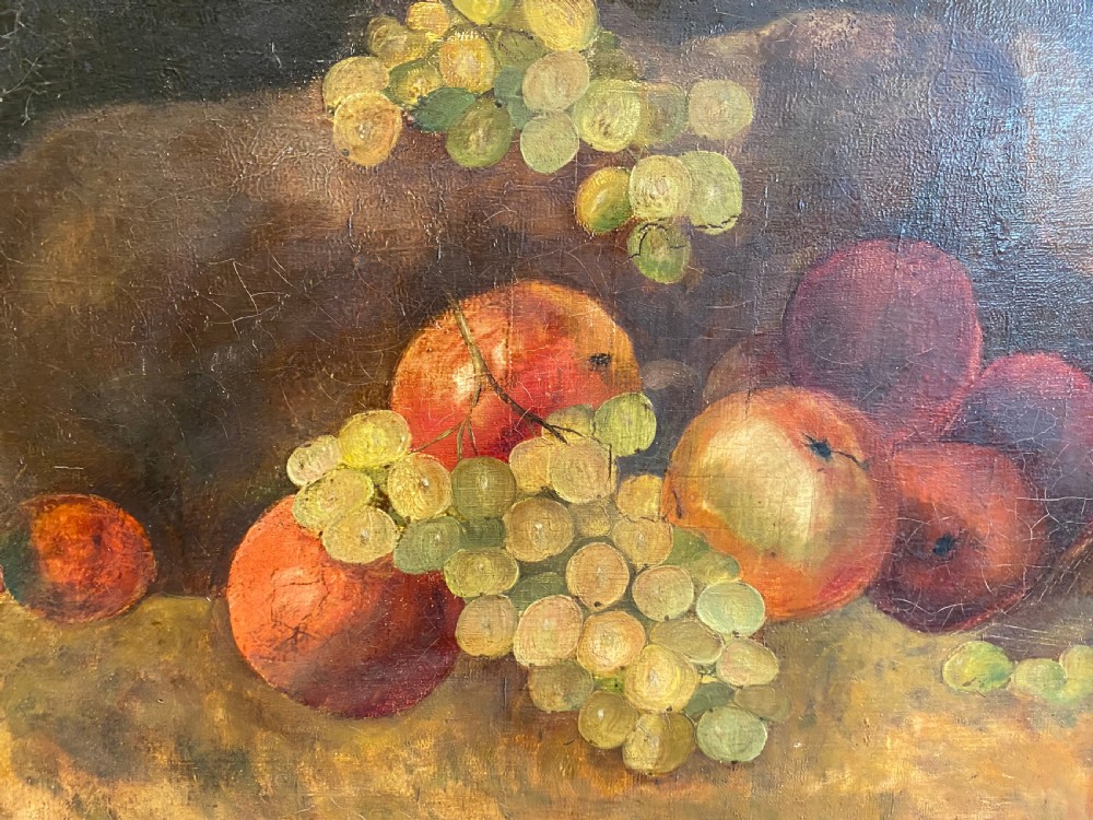 A framed oil painting depicting green grapes and red apples arranged on a tabletop against a dark background. View II
