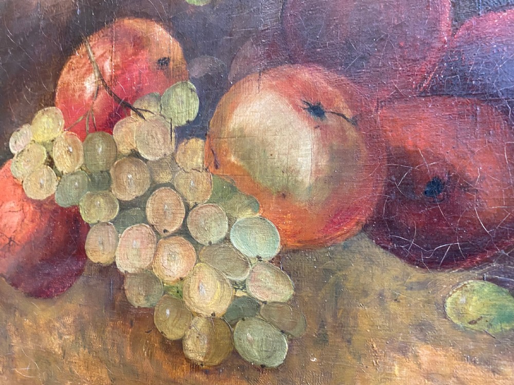 A framed oil painting depicting green grapes and red apples arranged on a tabletop against a dark background. View IV