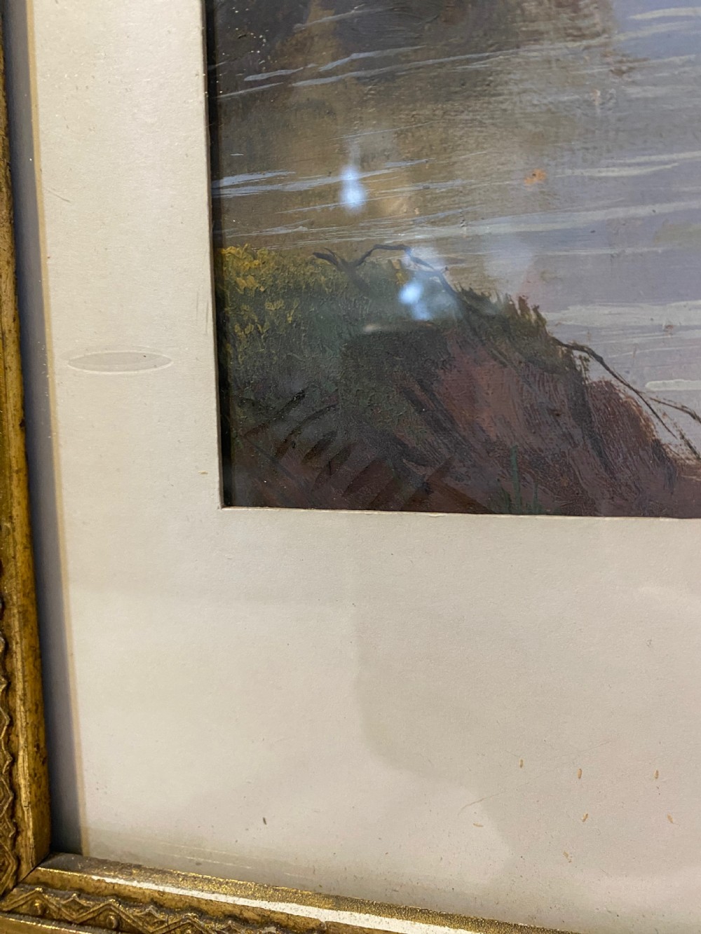 An antique watercolour painting depicting a river landscape with an arched bridge, set within a pointed arch aperture mount and a richly decorated gilt rectangular frame. View III