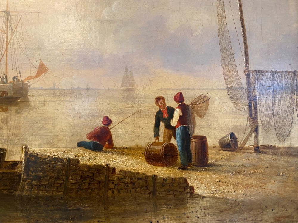 An early 19th-century marine oil painting depicting sailboats and fishermen in a harbour under a golden sky, set within a dark moulding frame with a gold slip. View III