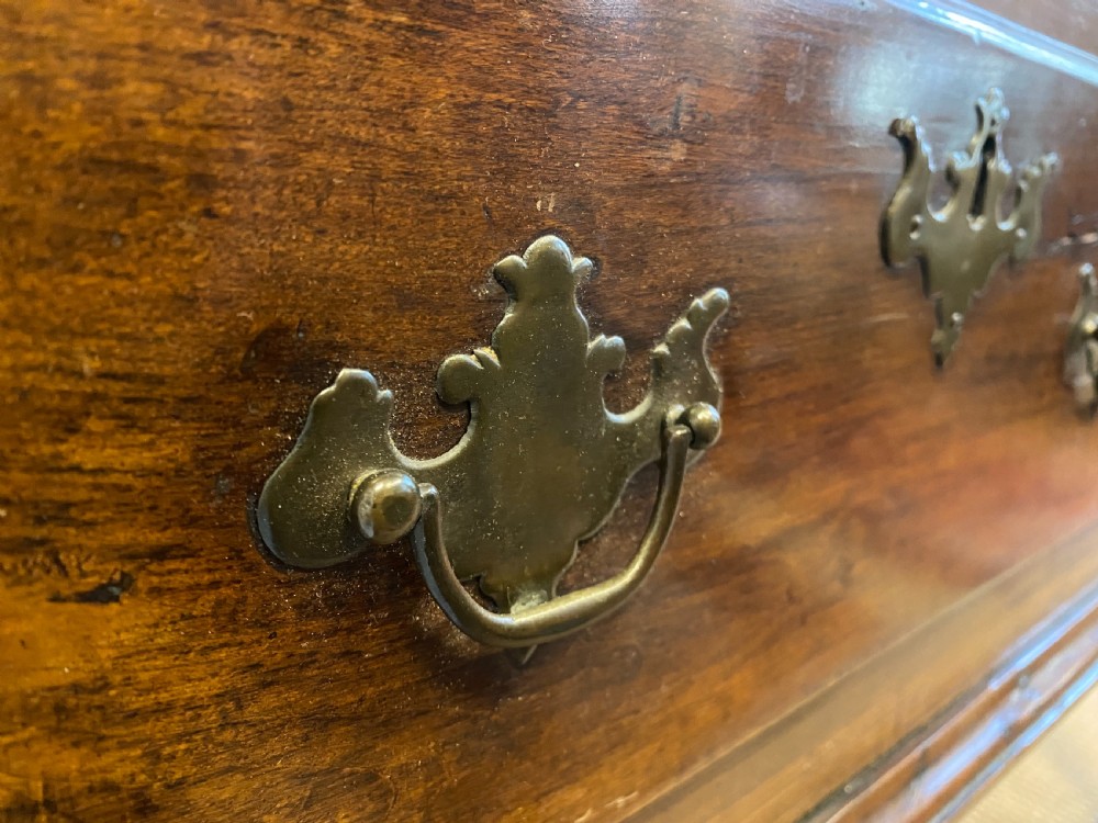 A mid-18th century walnut dresser base featuring two drawers with brass handles, supported on slender legs with pad feet. View II