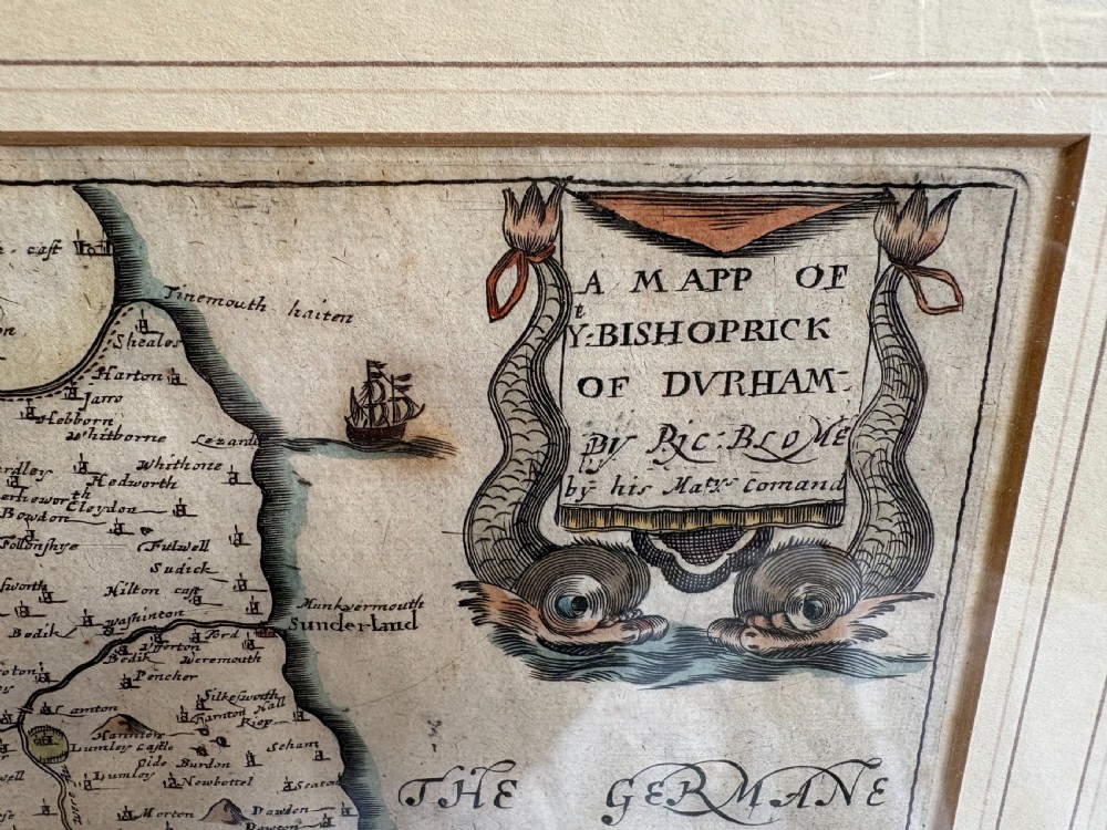 A framed 17th-century hand-coloured engraved map of County Durham by Richard Blome featuring a coat of arms and cartouche in a dark wood frame. View IX