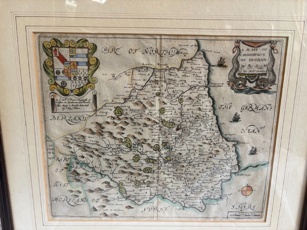 A framed 17th-century hand-coloured engraved map of County Durham by Richard Blome featuring a coat of arms and cartouche in a dark wood frame. View X