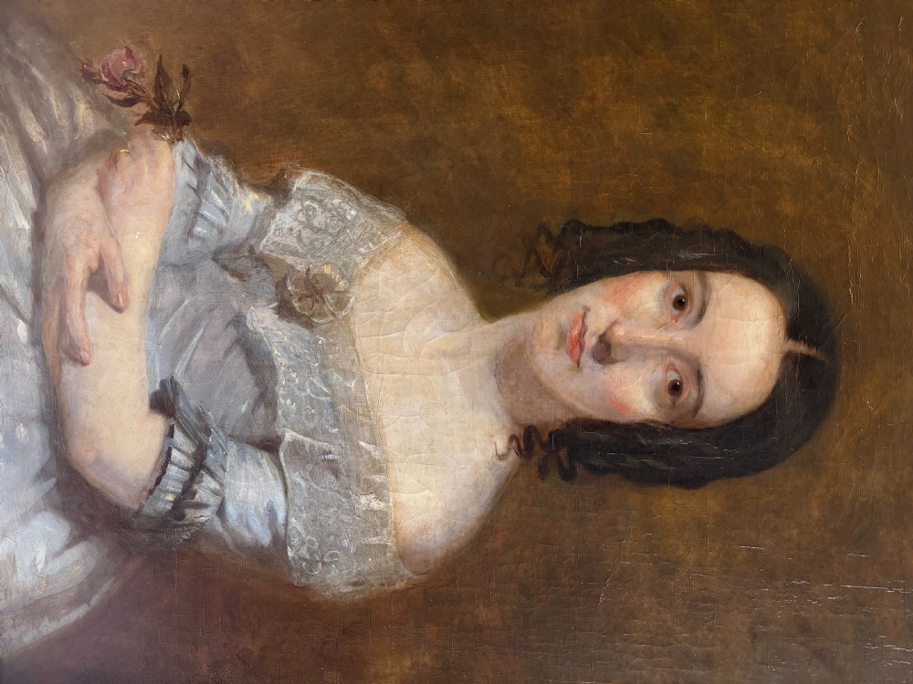 A mid-19th-century oil painting on canvas depicting a seated lady in a light blue dress with a lace collar, set inside a heavy gilded rectangular frame. View V