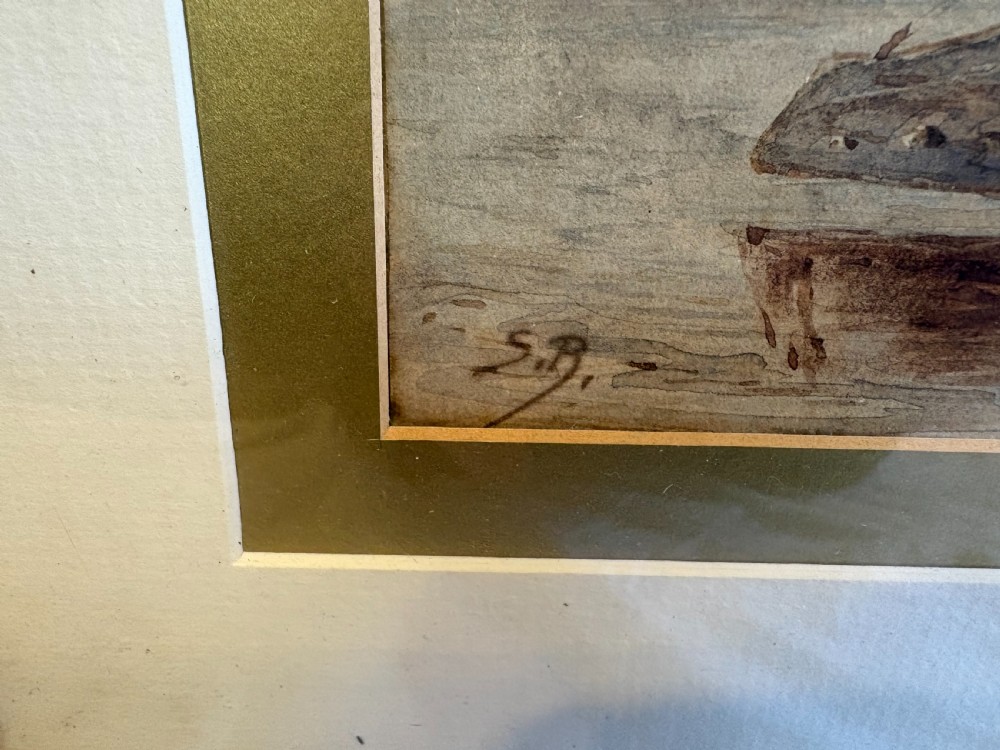 A 19th-century nautical watercolour depicting a wooden sailing vessel anchored in calm waters, enclosed in a cream mount and dark wooden frame with a carved gilt inner slip. View IV