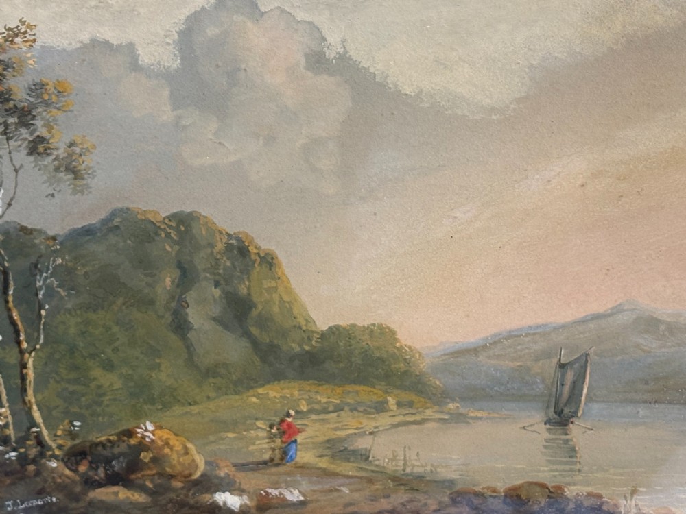An antique framed watercolour painting depicting a lakeside landscape with figures and a sailboat, set within a moulded gilt frame. View VI
