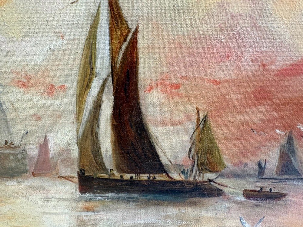 An Edwardian oil painting on canvas depicting sailing ships on calm water at sunset, set in a gold gilt frame. View VI