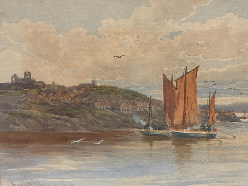 An Edwardian watercolour painting depicting fishing boats with reddish-brown sails in Whitby harbour, enclosed in a carved gilt frame. View V