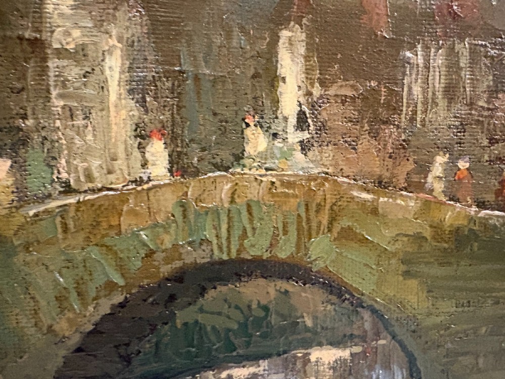 A framed 1940s oil painting depicting a stone arched bridge over a reflective canal surrounded by continental town buildings in muted tones. View III