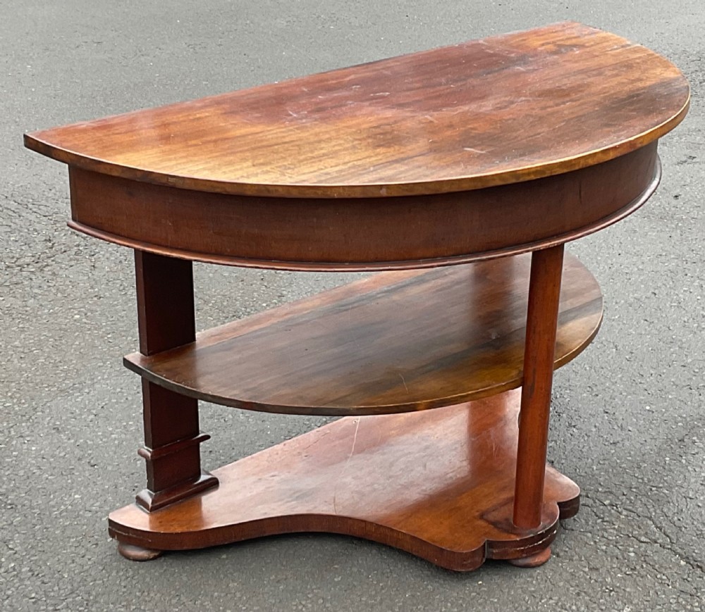 A Victorian mahogany demi-lune console table featuring a semicircular top, an intermediate tier shelf, and a shaped plinth base. View II