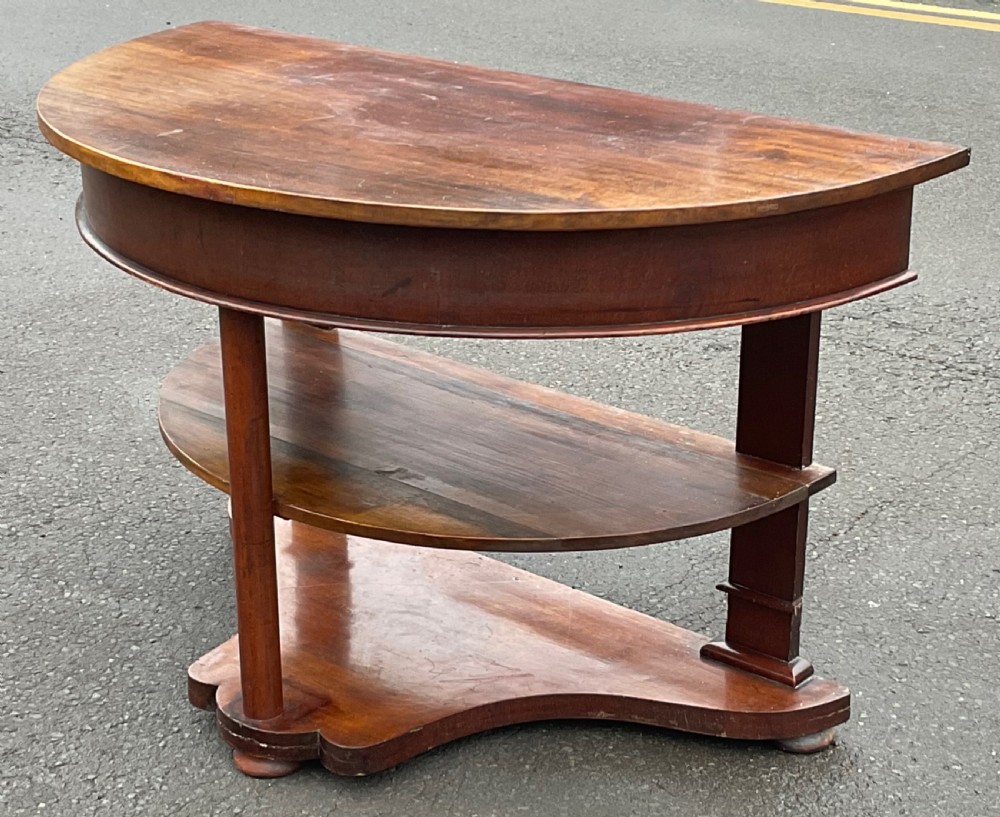 A Victorian mahogany demi-lune console table featuring a semicircular top, an intermediate tier shelf, and a shaped plinth base. View III