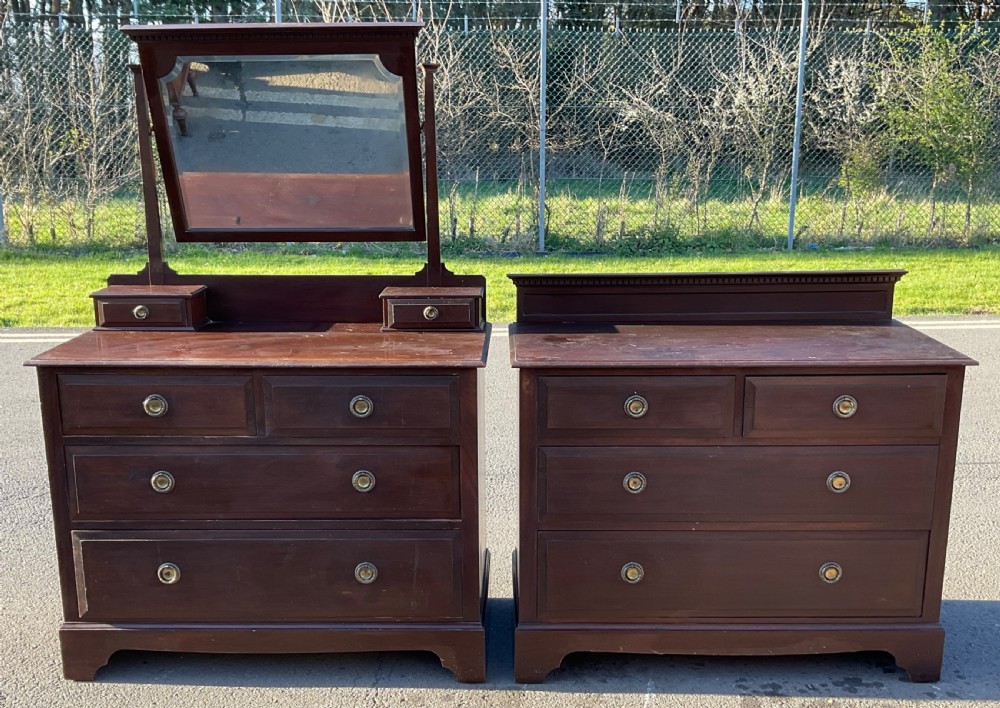 A pair of dark Edwardian mahogany furniture pieces featuring a dressing chest with a tilting mirror alongside a matching chest of drawers. View II