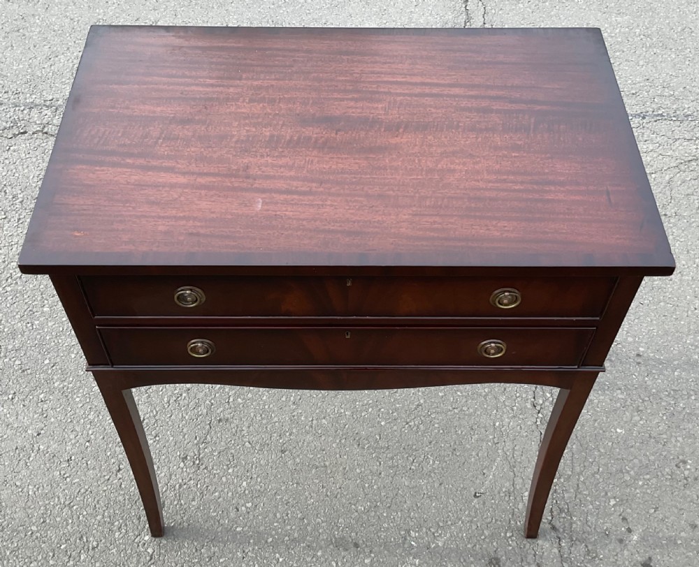 An Edwardian mahogany two-drawer chest featuring brass ring drop handles, flame mahogany veneer, and long tapered legs. View III