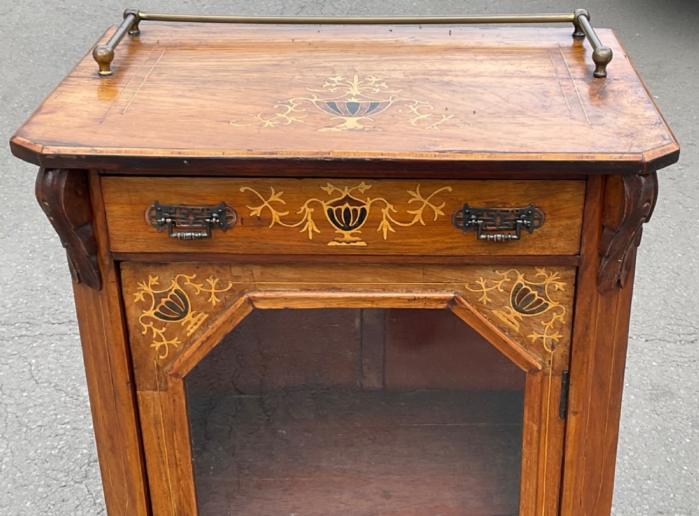 A Victorian walnut sheet music cabinet featuring floral marquetry inlay, a single glazed door with internal partitions, a top drawer, and a brass gallery rail. View II