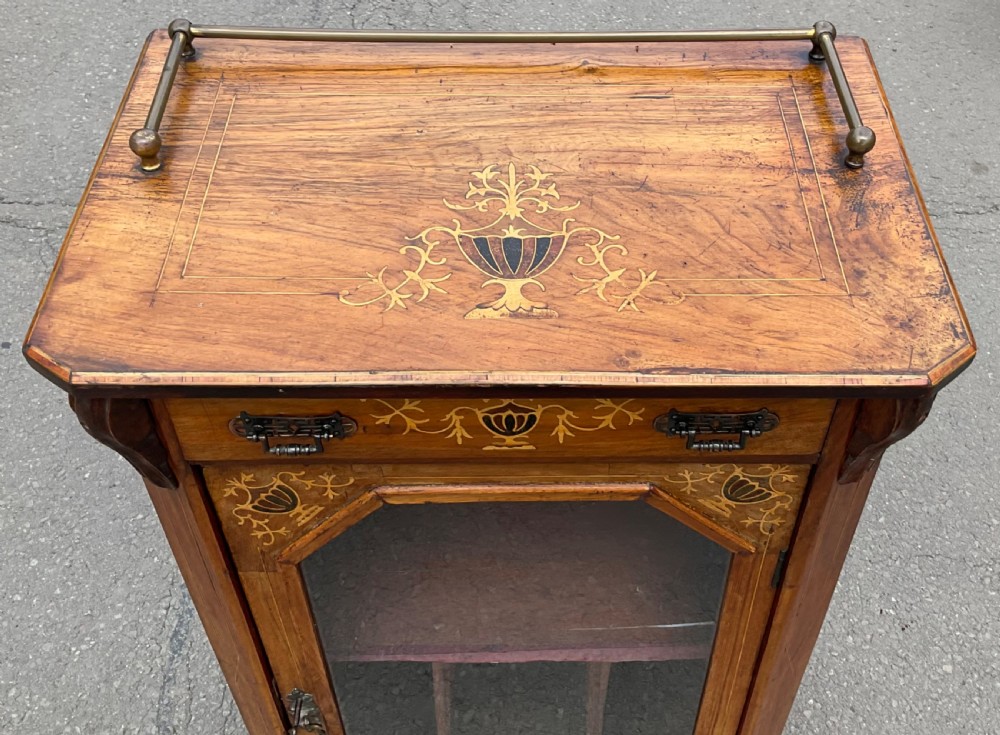 A Victorian walnut sheet music cabinet featuring floral marquetry inlay, a single glazed door with internal partitions, a top drawer, and a brass gallery rail. View VIII
